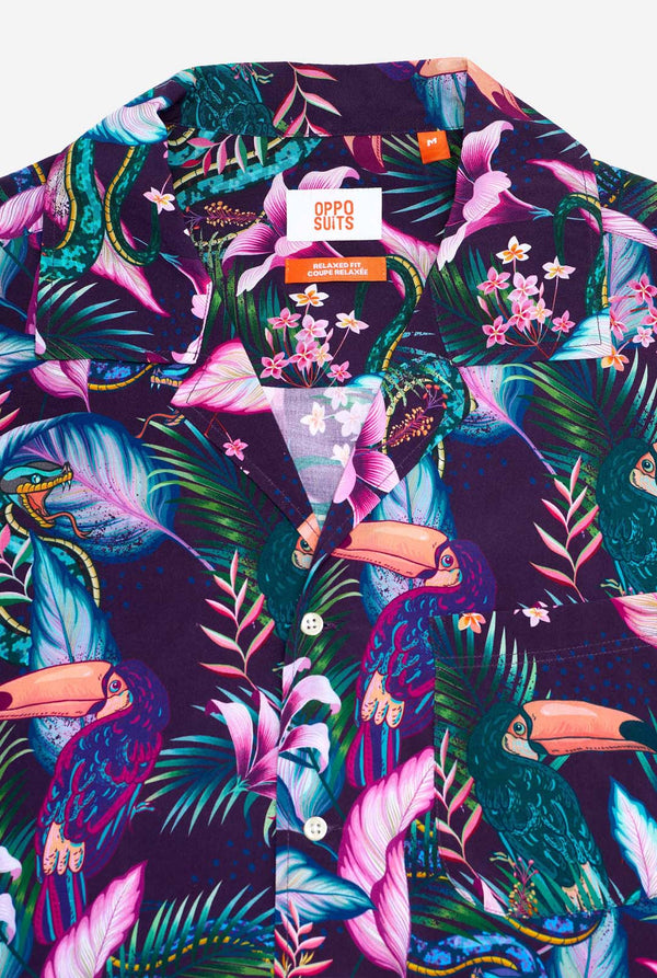 Das Bild zeigt ein lila Hawaiihemd mit tropischem Print, der an das Nachtleben im Dschungel erinnert. Der Print besteht aus Papageien, Schlangen, Blättern und Blumen. Nahaufnahme.