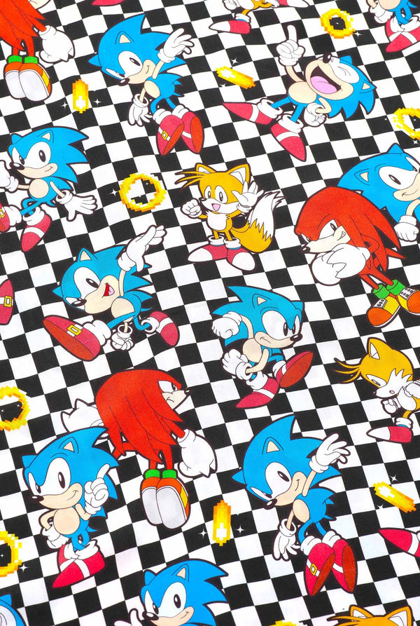 Nahaufnahme eines schwarz-weiß karierten Hawaiihemds mit Figuren aus der Sonic the Hedgehog-Reihe und goldenen Ringen. Gezeigt wird der Aufdruck mit verschiedenen Figuren wie Sonic, Knuckles, Tails und goldenen Ringen.