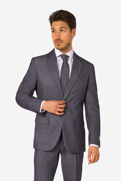 Ein Mann trägt einen stilvollen, anthrazitfarbenen Anzug mit weißem Hemd und wirkt selbstbewusst. Das perfekte formelle Outfit für besondere Anlässe, Hochzeiten und Partys.