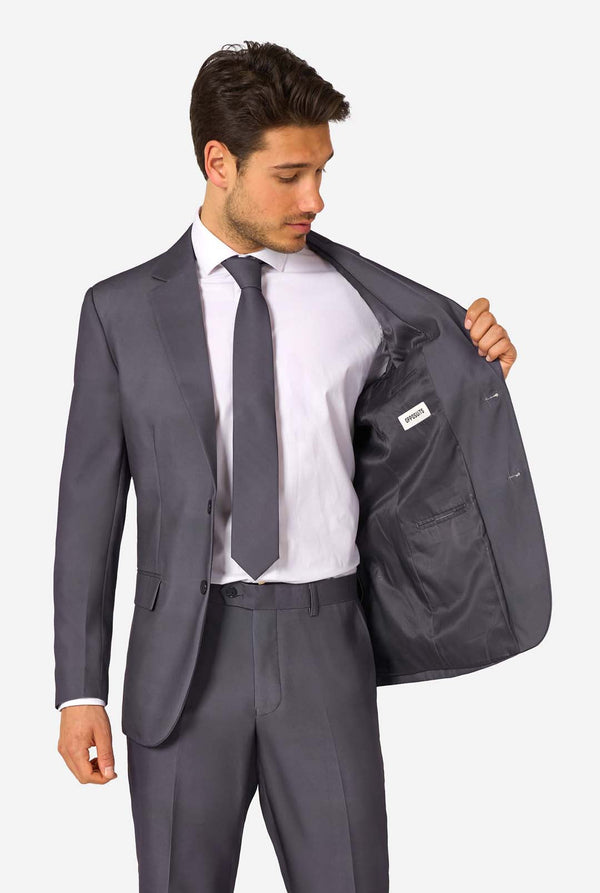 Ein Mann trägt einen stilvollen, anthrazitfarbenen Anzug mit weißem Hemd und wirkt selbstbewusst. Das perfekte formelle Outfit für besondere Anlässe, Hochzeiten und Partys.