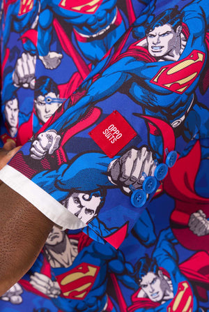 Ein Mann im Superman-Anzug mit roter Krawatte und weißem Hemd auf weißem Hintergrund. Nahaufnahme der Ärmel