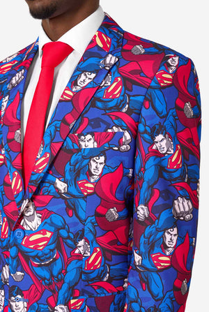 Ein Mann im Superman-Anzug mit roter Krawatte und weißem Hemd auf weißem Hintergrund. Nahaufnahme der Brust