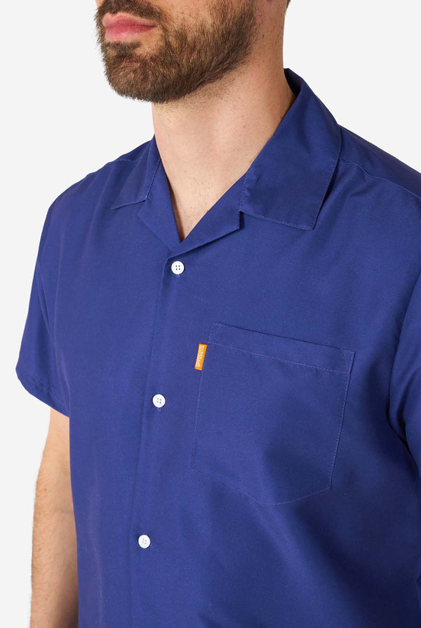 Mann trägt blaues Sommerset bestehend aus Hemd und Shorts, Nahaufnahme der Brust