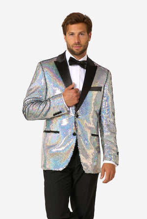 Mann, der einen holographischen silbernen Paillettentuxedo mit schwarzen Satin -Repfels trägt, gepaart mit einem weißen Hemd, einer schwarzen Fliege und einer schwarzen Hose.