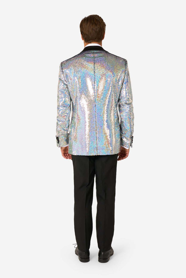 Mann, der einen holographischen silbernen Paillettentuxedo mit schwarzen Satin -Repfels trägt, gepaart mit einem weißen Hemd, einer schwarzen Fliege und einer schwarzen Hose.