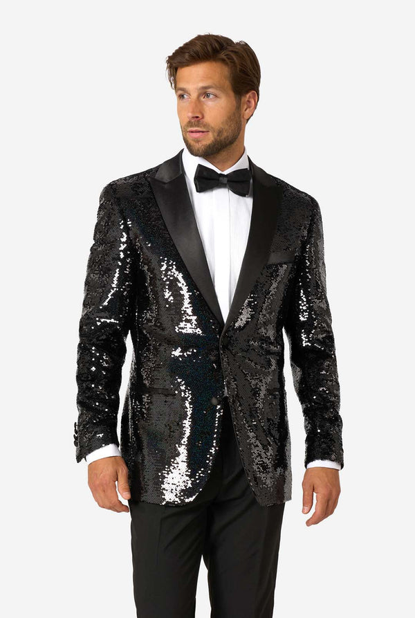 Mann trägt einen schwarzen Pailletten-Smoking mit Satin-Revers, ein weißes Hemd und eine schwarze Fliege.