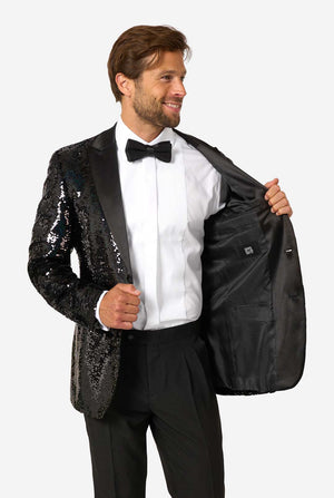 Mann trägt einen schwarzen Pailletten-Smoking mit Satin-Revers, ein weißes Hemd und eine schwarze Fliege.