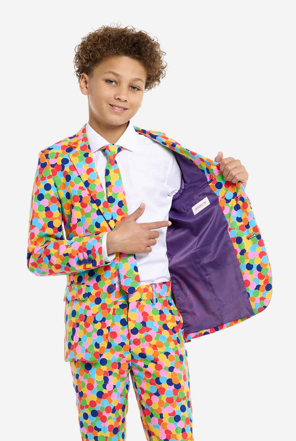 Kind trägt Jungenanzug mit Konfetti-Aufdruck