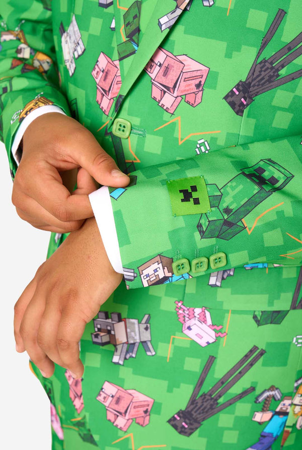 Ein Teenager in einem leuchtend grünen Minecraft-Anzug mit ikonischen Charakteren, darunter Creepers und Steve – Nahaufnahme der Ärmel