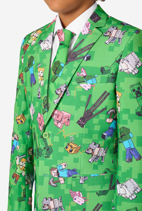 Ein Teenager in einem leuchtend grünen Minecraft-Anzug mit ikonischen Charakteren, darunter Creepers und Steve – Nahaufnahme der Brust
