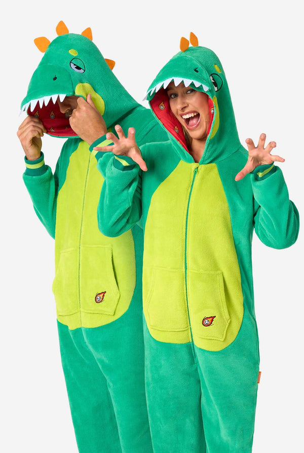 Ein Mann und eine Frau tragen grüne Dinosaurier-Erwachsenen-Onesies mit verspielten Kapuzen-Details und gemütlichem, weichem Material, perfekt zum Entspannen oder für Kostümveranstaltungen.