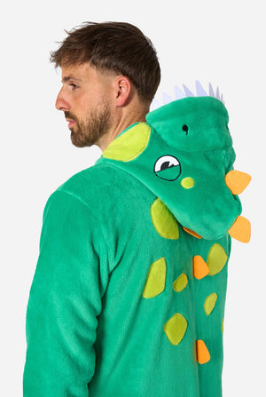 Ein Mann trägt einen grünen Dinosaurier-Einteiler für Erwachsene mit verspielten Kapuzendetails und kuscheligem, weichem Material – perfekt zum Entspannen oder für Kostümpartys. Er steht seitlich und hält die Kapuze über den Kopf. Nahaufnahme seines Oberkörpers.