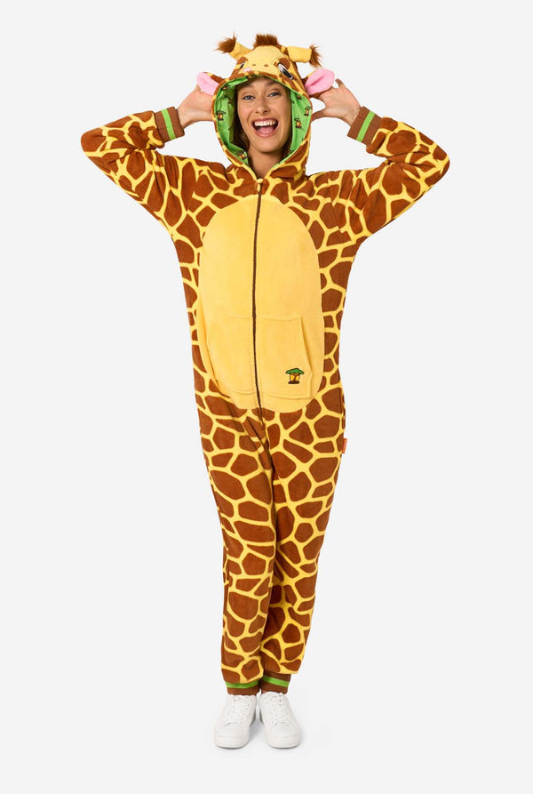 Eine lächelnde Frau trägt einen braunen und gelben Strampler für Erwachsene in Form einer Giraffe. Der Strampler hat eine Kapuze, die einem Giraffenkopf ähnelt, und Giraffendetails, perfekt zum gemütlichen Faulenzen oder für Kostümpartys. 