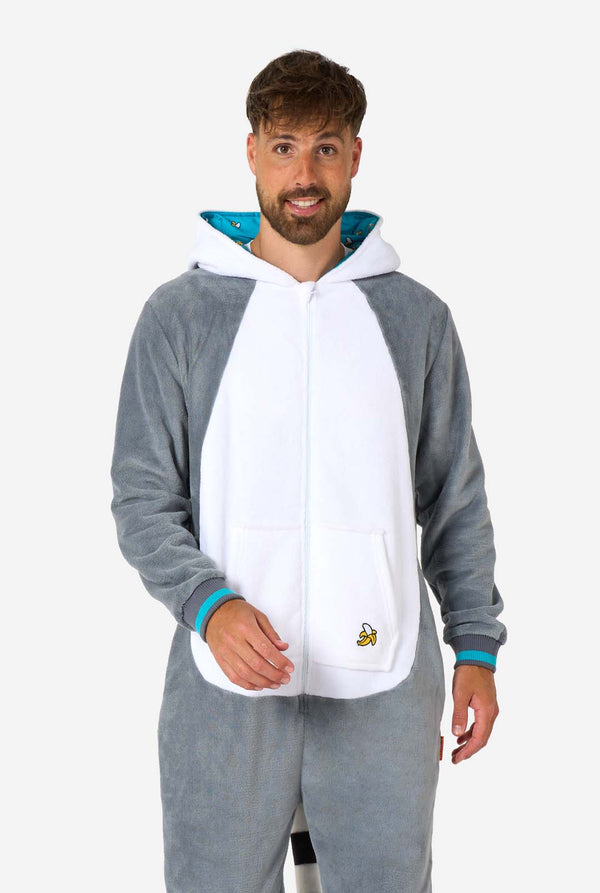 Ein Mann trägt einen grau-weißen Lemuren-Onesie für Erwachsene mit verspielten Kapuzendetails und kuscheligem, weichem Material, perfekt zum Entspannen oder für Kostümveranstaltungen. Inklusive schwarz-weißem Schwanz. Die Kapuze hängt auf seinem Rücken.