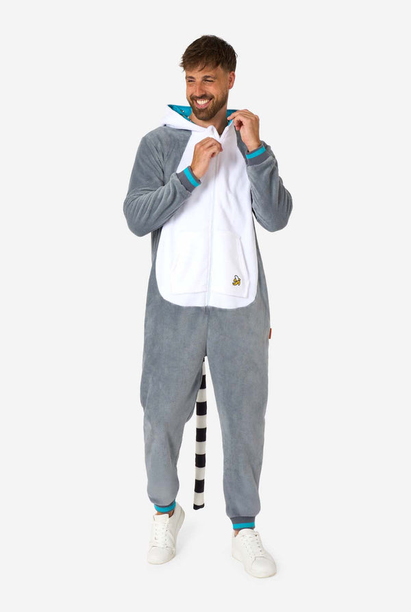 Ein Mann trägt einen grau-weißen Lemur-Onesie für Erwachsene mit verspielten Kapuzendetails und kuscheligem, weichem Material – perfekt zum Entspannen oder für Kostümveranstaltungen. Inklusive schwarz-weißem Schwanz. Ganzkörperbild mit heruntergelassener Kapuze und sichtbarem Schwanz.