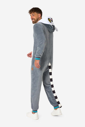 Ein Mann trägt einen grau-weißen Lemur-Onesie für Erwachsene mit verspielten Kapuzendetails und kuscheligem, weichem Material, perfekt zum Entspannen oder für Kostümveranstaltungen. Inklusive schwarz-weißem Schwanz. Ganzkörperbild von der Seite.