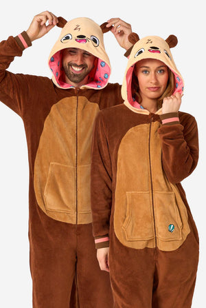 Ein lächelnder Mann und eine Frau tragen braune Erwachsenen-Onesies, die als Otter gestaltet sind. Der Onesie verfügt über eine Kapuze mit Ohren, ein niedliches Gesicht und verspielte Otter-Details, perfekt zum gemütlichen Entspannen oder für Kostümpartys.