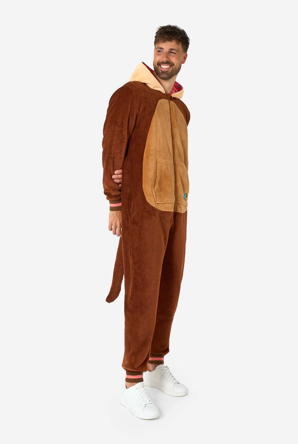 Ein lächelnder Mann trägt einen braunen Erwachsenen-Onesie in Otter-Optik. Der Onesie hat eine Kapuze mit Ohren, ein süßes Gesicht und verspielte Otter-Details – perfekt für gemütliches Faulenzen oder Kostümpartys. Ganzkörperbild: Der Mann steht und blickt zur Seite.