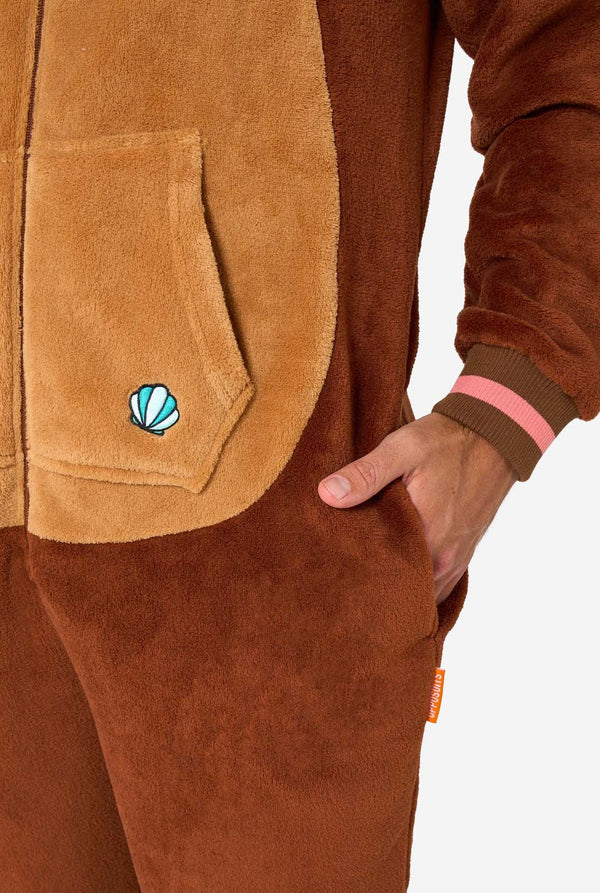 Ein lächelnder Mann trägt einen braunen Erwachsenen-Onesie in Otter-Optik. Der Onesie hat eine Kapuze mit Ohren, ein süßes Gesicht und verspielte Otter-Details – perfekt für gemütliches Faulenzen oder Kostümpartys. Nahaufnahme der Tasche.