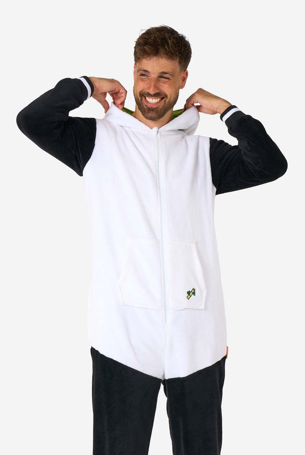 Ein lächelnder Mann trägt einen Panda-Onesie für Erwachsene. Dieser kuschelige Onesie ist in den Farben Schwarz und Weiß gehalten und hat eine verspielte Kapuze mit Pandaohren und einem süßen Gesicht. Perfekt zum Entspannen oder für lustige Kostümanlässe. Die Kapuze liegt flach auf dem Rücken.