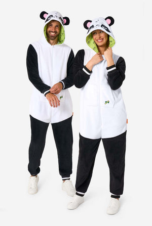 Ein Mann und eine Frau tragen Panda-motivierte Erwachsenen-Onesies. Diese gemütlichen Onesies zeigen die typischen schwarz-weißen Pandafarben und eine verspielte Kapuze mit Panda-Ohren und einem niedlichen Gesicht. Perfekt zum Entspannen oder für lustige Kostüm-Anlässe. Ganzkörperaufnahme.