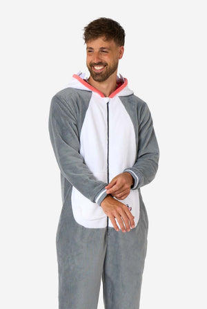 Ein Mann trägt einen grau-weißen Hai-Onesie für Erwachsene mit verspielten Kapuzendetails und kuscheligem, weichem Material, perfekt zum Entspannen oder für Kostümveranstaltungen. Die Kapuze liegt auf dem Rücken des Mannes.
