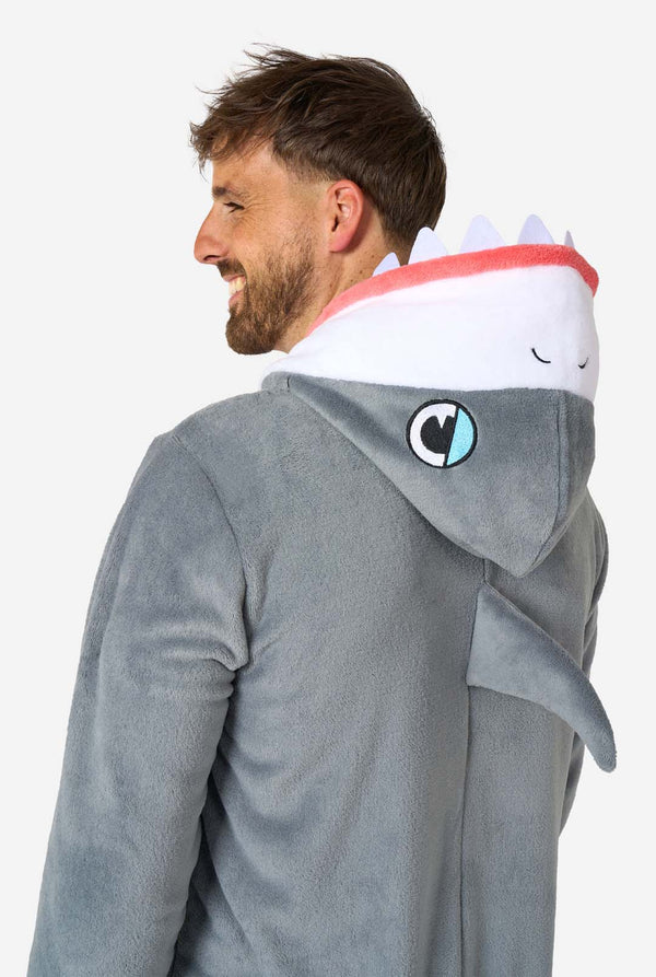 Ein Mann trägt einen grau-weißen Hai-Onesie für Erwachsene mit verspielten Kapuzendetails und kuscheligem, weichem Material, perfekt zum Entspannen oder für Kostümveranstaltungen. Nahaufnahme des Oberkörpers von hinten.