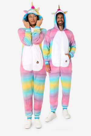 Ein Mann und eine Frau tragen einen farbenfrohen Strampler für Erwachsene in Form eines Regenbogen-Einhorns. Der Strampler hat einen leuchtenden Farbverlauf in Pastellfarben, ein goldenes Horn und verspielte Einhorn-Details - perfekt zum gemütlichen Faulenzen oder für Kostümpartys. Männer und Frauen haben jeweils eine Kapuze auf. Ganzkörperabbildung.
