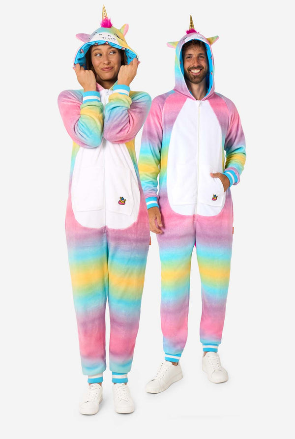 Ein Mann und eine Frau tragen einen farbenfrohen Strampler für Erwachsene in Form eines Regenbogen-Einhorns. Der Strampler hat einen leuchtenden Farbverlauf in Pastellfarben, ein goldenes Horn und verspielte Einhorn-Details - perfekt zum gemütlichen Faulenzen oder für Kostümpartys. Männer und Frauen haben jeweils eine Kapuze auf. Ganzkörperabbildung.