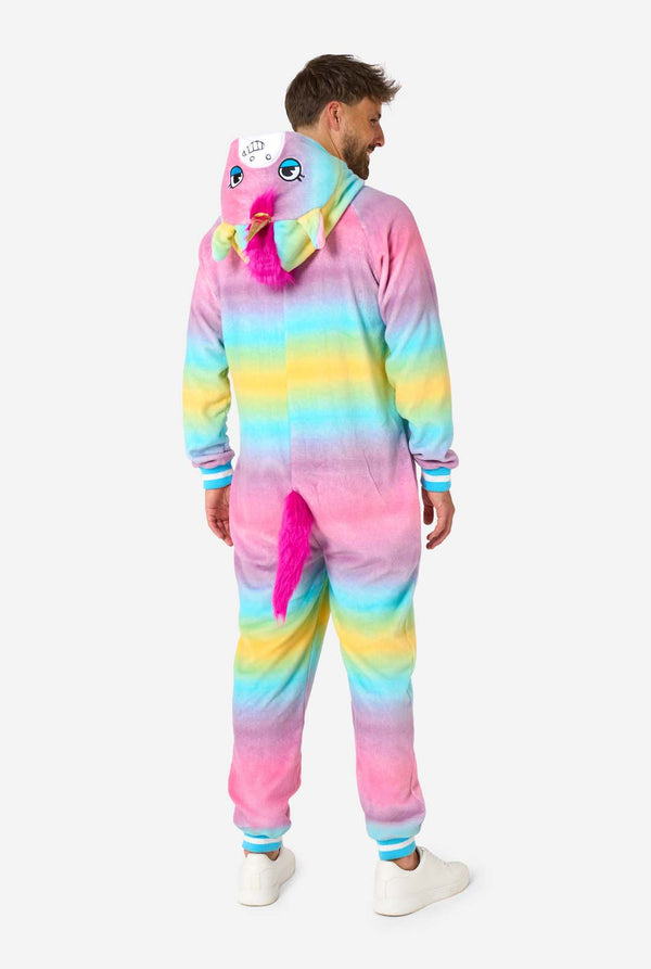 Ein Mann trägt einen farbenfrohen Einteiler für Erwachsene in Form eines Regenbogen-Einhorns. Der Einteiler besticht durch einen leuchtenden Farbverlauf in Pastellfarben, ein goldenes Horn und verspielte Einhorn-Details – perfekt für gemütliches Faulenzen oder Kostümpartys. Die Kapuze liegt flach auf seinem Rücken. Ansicht von hinten.