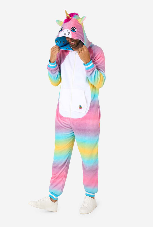 Ein Mann trägt einen farbenfrohen Einteiler für Erwachsene in Form eines Regenbogen-Einhorns. Der Einteiler besticht durch einen leuchtenden Farbverlauf in Pastellfarben, ein goldenes Horn und verspielte Einhorn-Details – perfekt für gemütliches Faulenzen oder Kostümpartys. Ganzkörperaufnahme, der Mann blickt auf den Boden.
