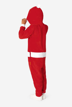 Kind leicht zur Seite gedreht, hebt die Kapuze eines roten Santa-Onesies an und zeigt die weiße Bommel auf der Rückseite.