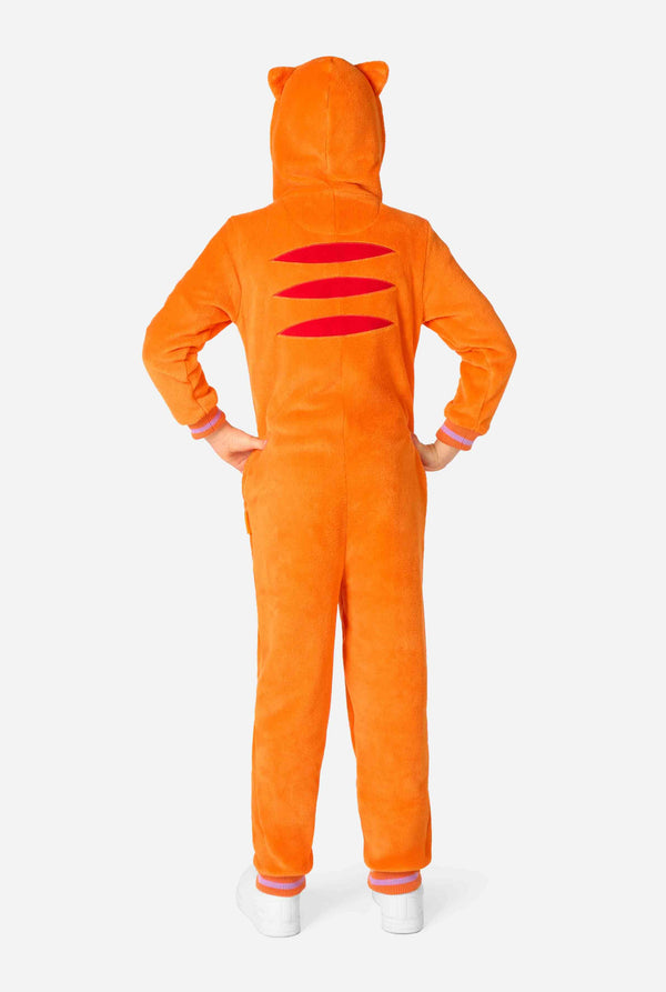 Kind trägt einen verspielten, unisex Kinder-Onesie im Design einer rot-orangefarbenen Katze, mit Kapuze, die ein Cartoon-Katzengesicht und Ohren zeigt, sowie einem hellbeigen Bauchpaneel. Das Kind zieht eine lustige Grimasse vor einem schlichten Hintergrund. Ansicht von hinten.