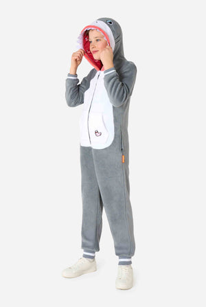 Ein Kind trägt einen grau-weißen Hai-Einteiler für Kinder mit verspielten Kapuzendetails und kuscheligem, weichem Material, perfekt zum Entspannen oder für Kostümveranstaltungen. Ganzkörperbild.