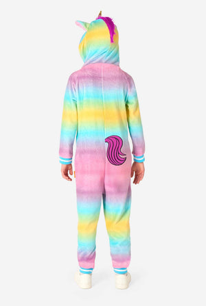 Ein lächelndes Kind trägt einen weißen, rosa, blauen und gelben Kinderstrampler, der als Einhorn gestaltet ist. Der Einhorn-Einteiler verfügt über eine Kapuze, die einem Einhornkopf ähnelt, und weitere verspielte Details. Ansicht von hinten, Ganzkörper.