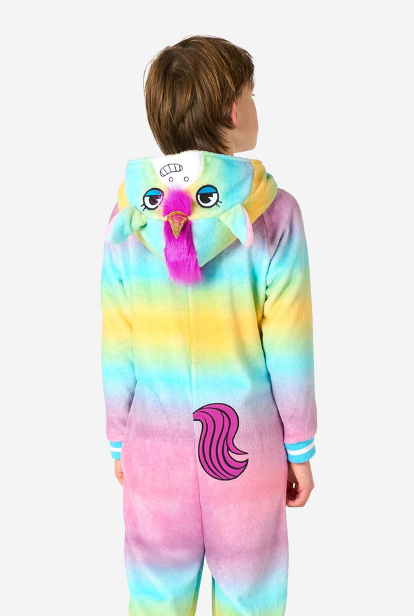 Ein lächelndes Kind trägt einen weißen, rosa, blauen und gelben Kinderstrampler, der als Einhorn gestaltet ist. Der Einhorn-Einteiler verfügt über eine Kapuze, die einem Einhornkopf ähnelt, und weitere verspielte Details. Ansicht von hinten.