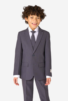 Junge in einem eleganten, anthrazitfarbenen Anzug mit weißem Hemd und selbstbewusstem Lächeln. Perfektes formelles Outfit für besondere Anlässe, Hochzeiten und Partys.
