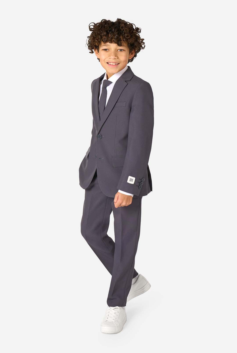 Junge in einem eleganten, anthrazitfarbenen Anzug mit weißem Hemd und selbstbewusstem Lächeln. Perfektes formelles Outfit für besondere Anlässe, Hochzeiten und Partys.