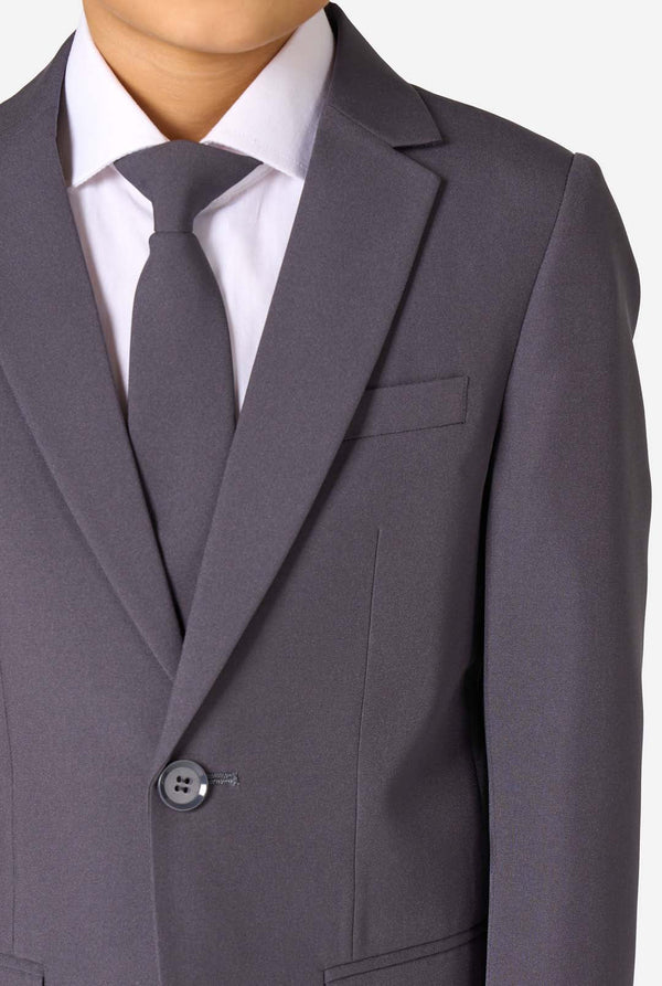 Junge in einem eleganten, anthrazitfarbenen Anzug mit weißem Hemd und selbstbewusstem Lächeln. Perfektes formelles Outfit für besondere Anlässe, Hochzeiten und Partys.