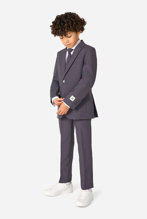 Junge in einem eleganten, anthrazitfarbenen Anzug mit weißem Hemd und selbstbewusstem Lächeln. Perfektes formelles Outfit für besondere Anlässe, Hochzeiten und Partys.