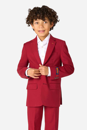 Kind trägt einen stilvollen bordeauxroten Anzug mit weißem Hemd, schaut selbstbewusst. Perfektes festliches Outfit für besondere Anlässe, Hochzeiten und Partys von Jungen.