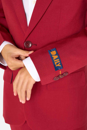 Kind trägt einen stilvollen bordeauxroten Anzug mit weißem Hemd, schaut selbstbewusst. Perfektes festliches Outfit für besondere Anlässe, Hochzeiten und Partys von Jungen. Nahaufnahme des Ärmels.