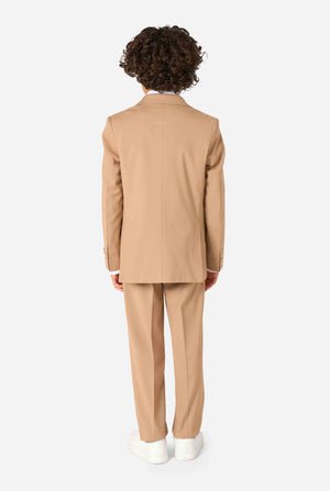 Kind trägt einen stilvollen hellbraunen/beigen Anzug mit weißem Hemd, schaut weg von der Kamera. Perfektes festliches Outfit für besondere Anlässe, Hochzeiten und Partys von Jungen. Ansicht von hinten.
