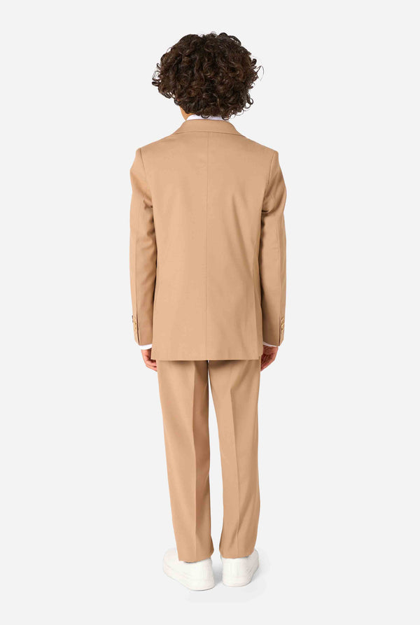 Kind trägt einen stilvollen hellbraunen/beigen Anzug mit weißem Hemd, schaut weg von der Kamera. Perfektes festliches Outfit für besondere Anlässe, Hochzeiten und Partys von Jungen. Ansicht von hinten.
