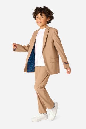 Kind trägt einen stilvollen hellbraunen/beigen Anzug mit weißem Hemd, schaut weg von der Kamera. Perfektes festliches Outfit für besondere Anlässe, Hochzeiten und Partys von Jungen.