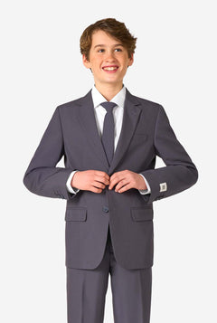 Teenager in einem stylischen anthrazitfarbenen Anzug mit weißem Hemd und selbstbewusstem Lächeln. Perfektes formelles Outfit für besondere Anlässe, Hochzeiten und Partys.