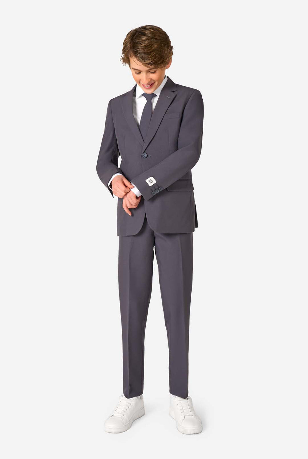 Teenager in einem stylischen anthrazitfarbenen Anzug mit weißem Hemd und selbstbewusstem Lächeln. Perfektes formelles Outfit für besondere Anlässe, Hochzeiten und Partys.