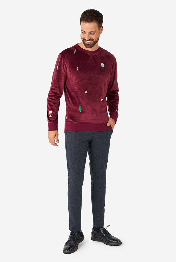 Mann, der Velvet Burgund rotes Weihnachtspullover mit Weihnachtsikonen trägt