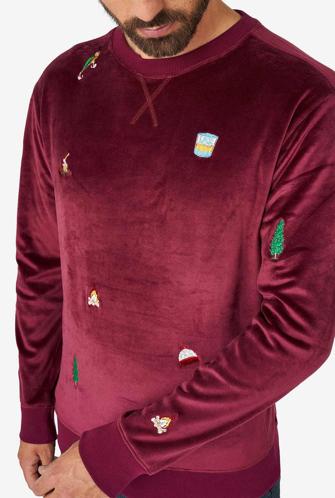 Mann, der Velvet Burgund rotes Weihnachtspullover mit Weihnachtsikonen trägt, Nahaufnahme