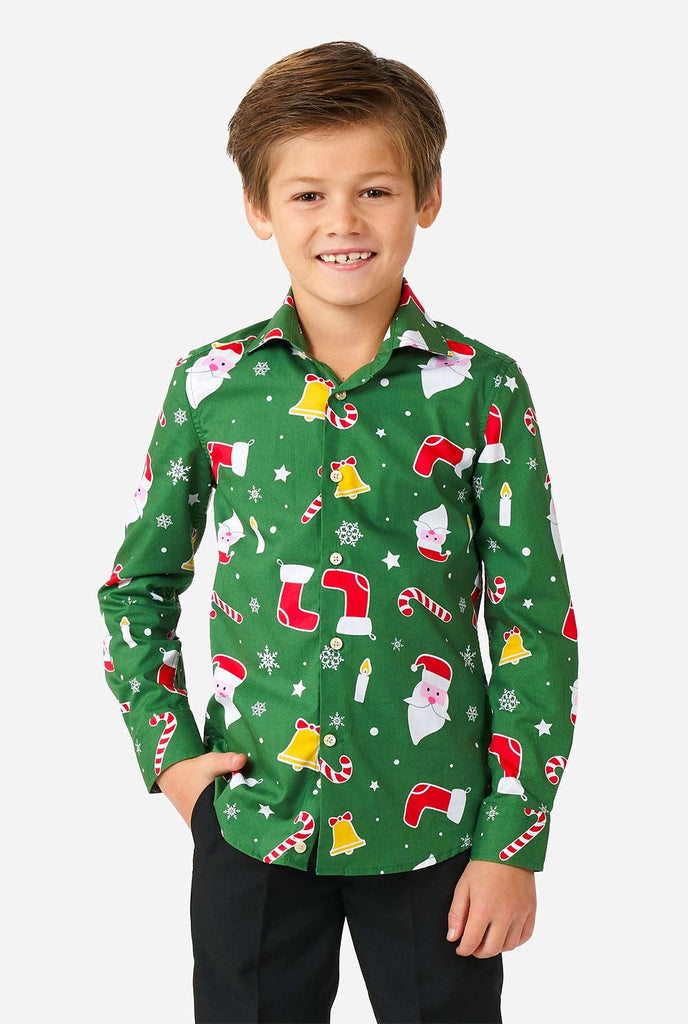 Kind, das ein grünes Weihnachtshemd mit Weihnachtsikonen trägt